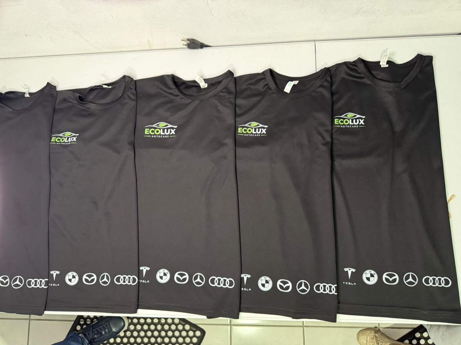 Lote de playeras negras personalizadas con logotipo Ecolux